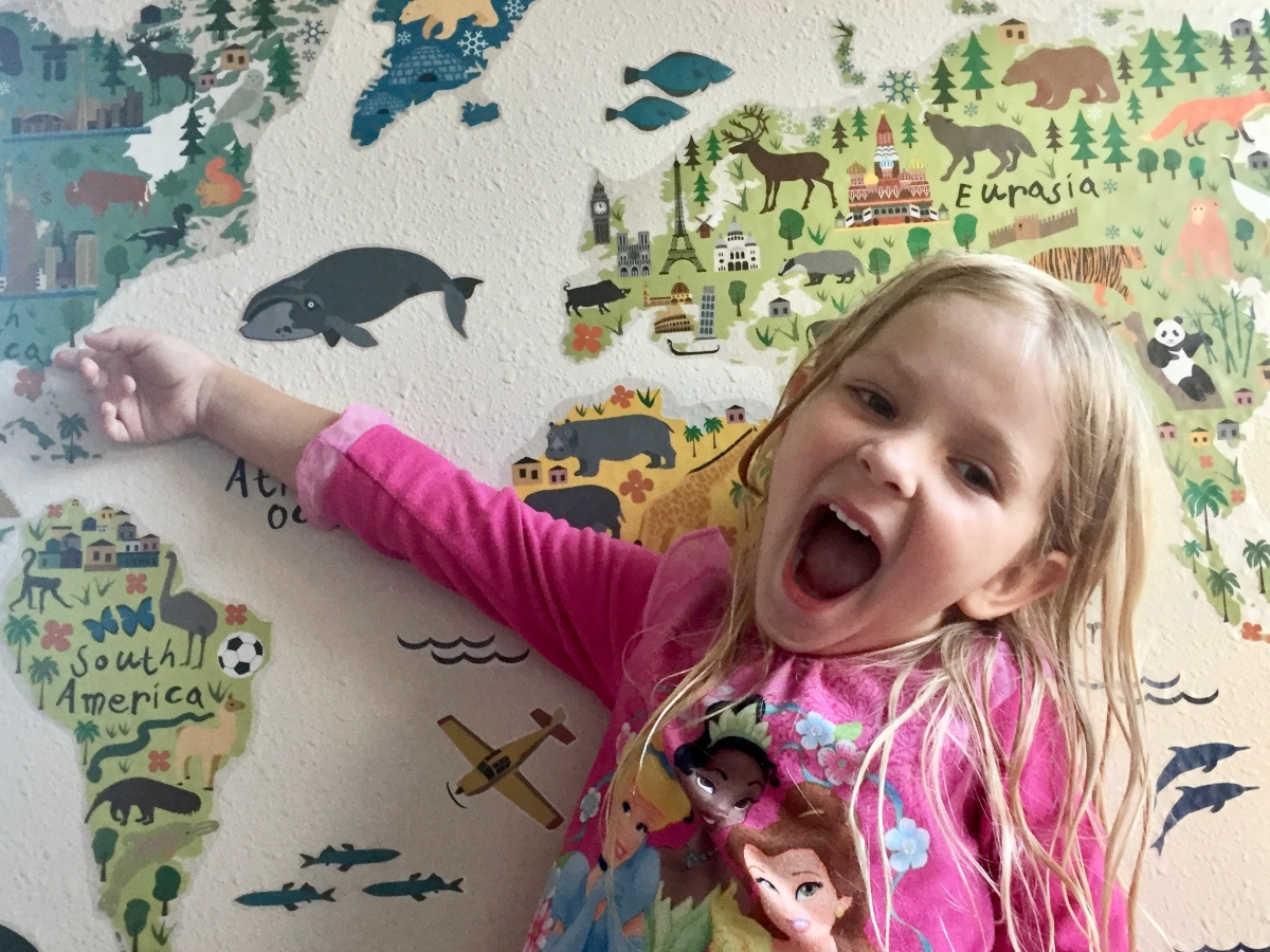 Little Girl Pointing to Wall Map