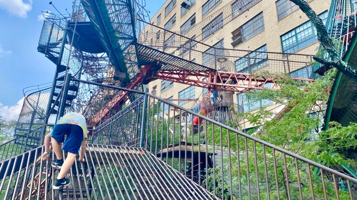 boy Climbing up a metal slide in the Outside play area of the City Museum in St. Louis, Missouri